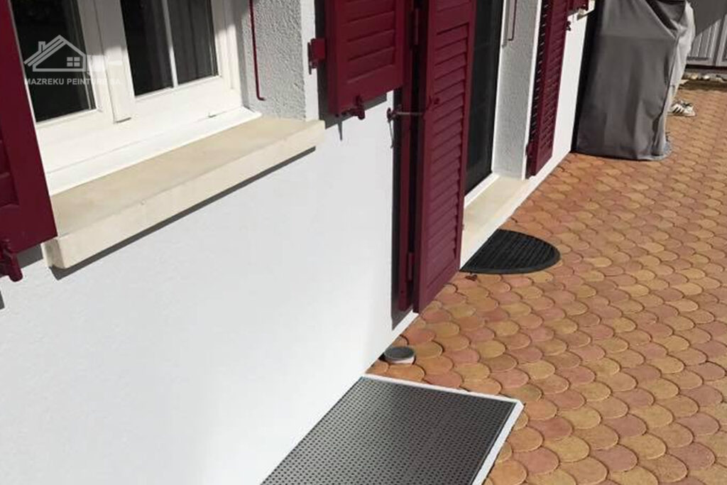 Détail de façade rénovée avec volets bordeaux